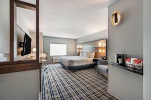 a hotel room with a bed and a television at AmericInn by Wyndham Fairfield in Fairfield +47 photos