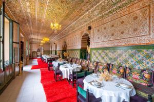 a dining room with tables and chairs and a red carpet at La Kasbah d'Ourika - Hôtel Restaurant & Spa in Ourika