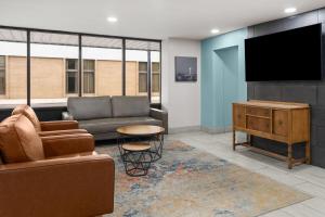 a living room with a couch and a flat screen tv at Baymont by Wyndham Great Falls City Center in Great Falls