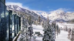 a snow covered mountain with trees and a building at Everline Resort and Spa, Lake Tahoe in Olympic Valley