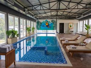 a large swimming pool with a mural on the wall at Arista Haven Hotel in Rishīkesh