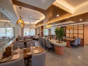 a restaurant with wooden ceilings and tables and chairs at Arista Haven Hotel in Rishīkesh