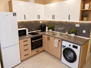 a kitchen with white cabinets and a washer and dryer at Apartment The Garden Ruse, Private Garden & Free Parking in Ruse