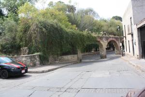 um carro estacionado numa rua ao lado de uma ponte de pedra em Arquitectos Departamento 11-2 em Guanajuato