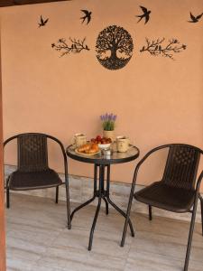 a table with two chairs and birds on a wall at Apartment The Garden Ruse, Private Garden & Free Parking in Ruse