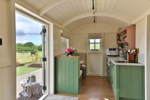 a kitchen with green cabinets and an arched ceiling at Hornbeam Holt in Broadway