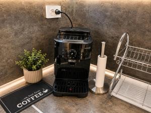 a black coffee maker sitting on a kitchen counter at Apartment The Garden Ruse, Private Garden & Free Parking in Ruse +45 photos