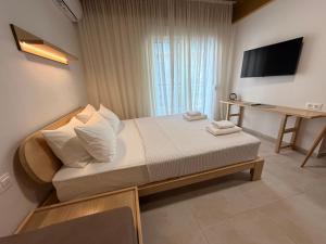 a small bedroom with a bed and a television at Aurora Suite in Xanthi