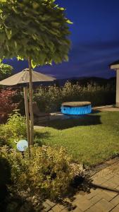 a bench with an umbrella in a yard at Amavi Homes With Garden in Alba Iulia