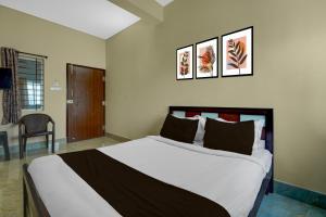 a bedroom with a large bed with three pictures on the wall at Hotel O Abbigere Lakeview Bangalore Formerly Shree Venkateshwar Atithi Comforts in Chik Bānavar +35 photos