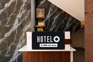 a hotel sign on a counter in a lobby at Hotel O Abbigere Lakeview Bangalore Formerly Shree Venkateshwar Atithi Comforts in Chik Bānavar