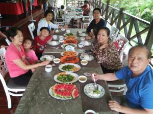 een groep mensen die aan een tafel eten bij Benarat Lodge in Mulu