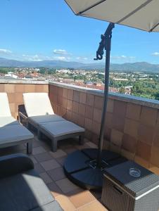 a patio with an umbrella and a table and chairs at Soleado ático en Salvaterra de Miño in Salvatierra de Miño