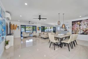 a dining room and living room with a table and chairs at Villa Aura - Private Pool - Lakefront & Near Beach in Trinity Beach