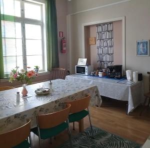 a dining room with a large table with chairs at Hostelli Marja in Mikkeli +18 photos