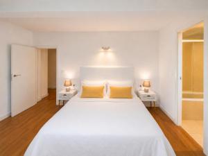 a bedroom with a large white bed with yellow pillows at Holibai Nova Anduriña, Casa rustica con jardín, Gondomar in Gondomar