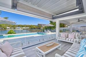 an outdoor patio with a table and chairs and a pool at Villa Aura - Private Pool - Lakefront & Near Beach in Trinity Beach +21 photos