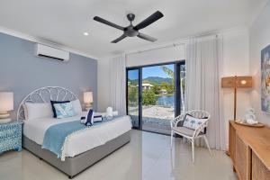 a bedroom with a bed and a view of the ocean at Villa Aura - Private Pool - Lakefront & Near Beach in Trinity Beach