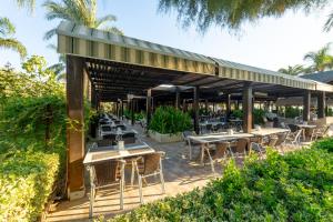 an outdoor patio with tables and chairs and trees at Sunis Kumköy Beach Resort Hotel & Spa in Side