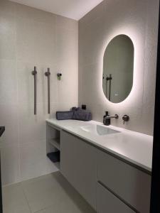 a white bathroom with a sink and a mirror at AUTRA Resort Middleton in Middleton