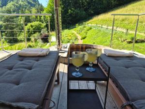 two glasses of wine sitting on a table on a deck at Herbal Garden Resort Plahtica in Jurklošter