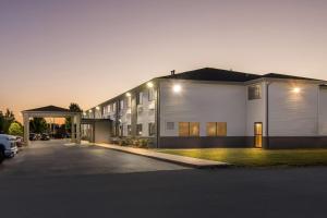 ein großes weißes Gebäude mit einem Parkplatz in der Unterkunft Super 8 by Wyndham Bourbonnais/Kankakee Area in Bourbonnais