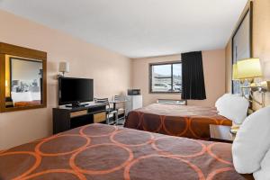 ein Hotelzimmer mit Bett und Flachbildfernseher in der Unterkunft Super 8 by Wyndham Bourbonnais/Kankakee Area in Bourbonnais