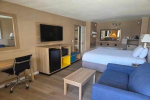 a hotel room with a bed and a couch and a tv at Days Inn by Wyndham Alhambra CA in Alhambra