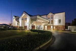a large house is lit up at night at Days Inn & Suites by Wyndham Ridgeland in Ridgeland