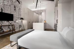 a bedroom with a white bed and a tv at The Heid Lofts by Reside, a Wyndham Residence in Philadelphia
