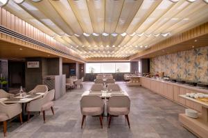 a restaurant with tables and chairs and a cafeteria at Keys Lite by Lemon Tree Hotels, Ajmer in Ajmer