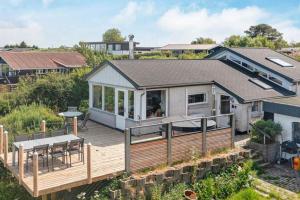 a house with a deck with a table and chairs at Cottage With A View in Roslev