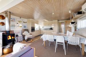 a kitchen with a table and chairs and a fireplace at Cottage With A View in Roslev +23 photos