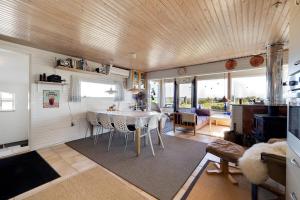 a kitchen and living room with a table and chairs at Cottage With A View in Roslev