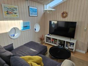 a living room with a couch and a flat screen tv at Cottage With A View in Roslev