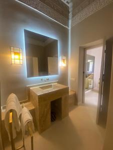 a bathroom with a sink and a mirror at Riad Djannaat Exceptional private riad pool staff in Marrakesh