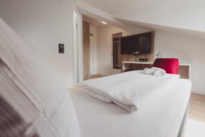 a bedroom with a white bed with towels on it at Hotel City Green Hoppegarten in Hoppegarten