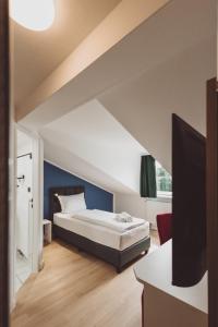 a bedroom with a bed and a tv at Hotel City Green Hoppegarten in Hoppegarten