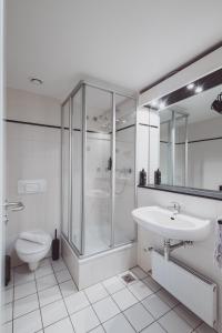 a bathroom with a shower and a sink and a toilet at Hotel City Green Hoppegarten in Hoppegarten