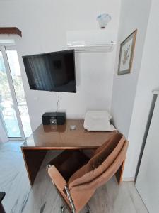 a desk with a television on a wall with a chair at Areti & Maria Apartments in Gythio +54 photos