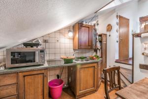 a kitchen with wooden cabinets and a microwave at Champlas Suite - Happy Rentals in Sestriere