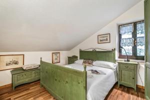 a bedroom with a bed with green furniture and windows at Champlas Suite - Happy Rentals in Sestriere