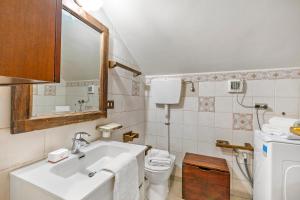 a bathroom with a sink and a toilet and a mirror at Champlas Suite - Happy Rentals in Sestriere