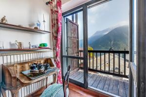 a room with a table and a balcony with a view at Champlas Suite - Happy Rentals in Sestriere