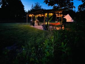 un gazebo illuminato in un campo di notte di Eglīši a Kalnamuiža