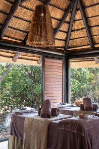 a group of tables in a room with windows at Ndlovu Safari Lodge in Vaalwater