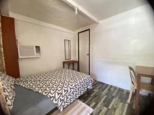 a small bedroom with a bed and a table at Beachaus Resort in Pandan