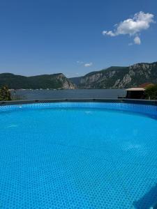 a large blue swimming pool with mountains in the background at CasaA&B in Dubova