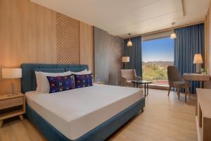 a bedroom with a large white bed and a window at Keys Lite by Lemon Tree Hotels, Ajmer in Ajmer