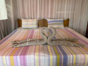 a pair of towel animals on a bed at Beachaus Resort in Pandan